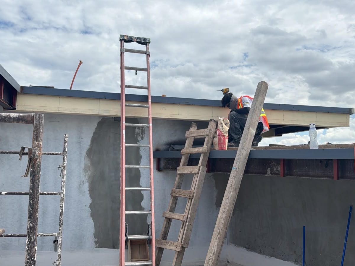 Cuadrilla de Kinofibras instalando enchapado en el borde de losa de una casa en construcción